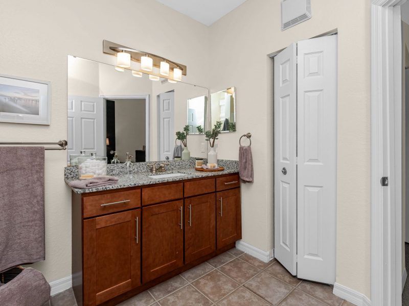 Modern bathroom with dual-sink vanity and granite countertop at TGM University Park.