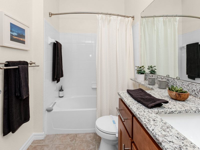 Modern bathroom with granite countertop and stylish fixtures at TGM University Park.