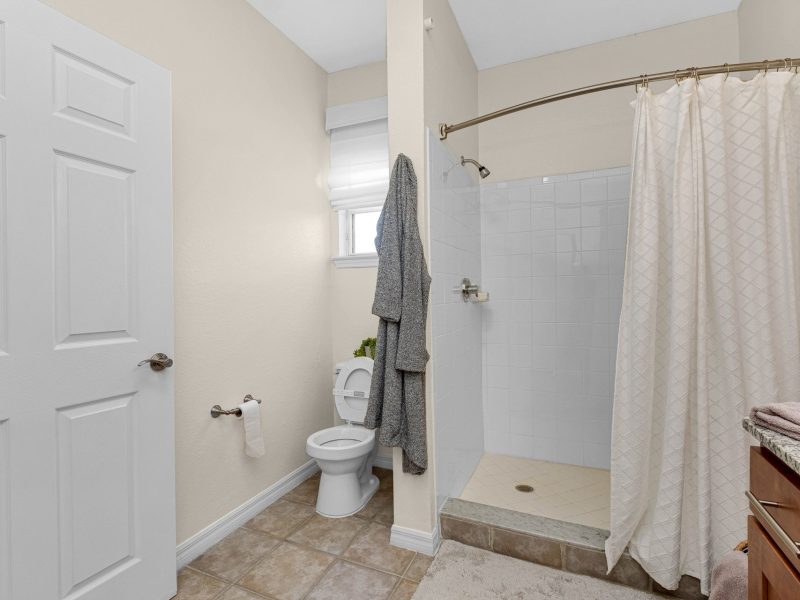 Modern beige bathroom with shower and vanity at TGM University Park apartments.